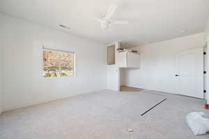 Unfurnished living room with light carpet and ceiling fan