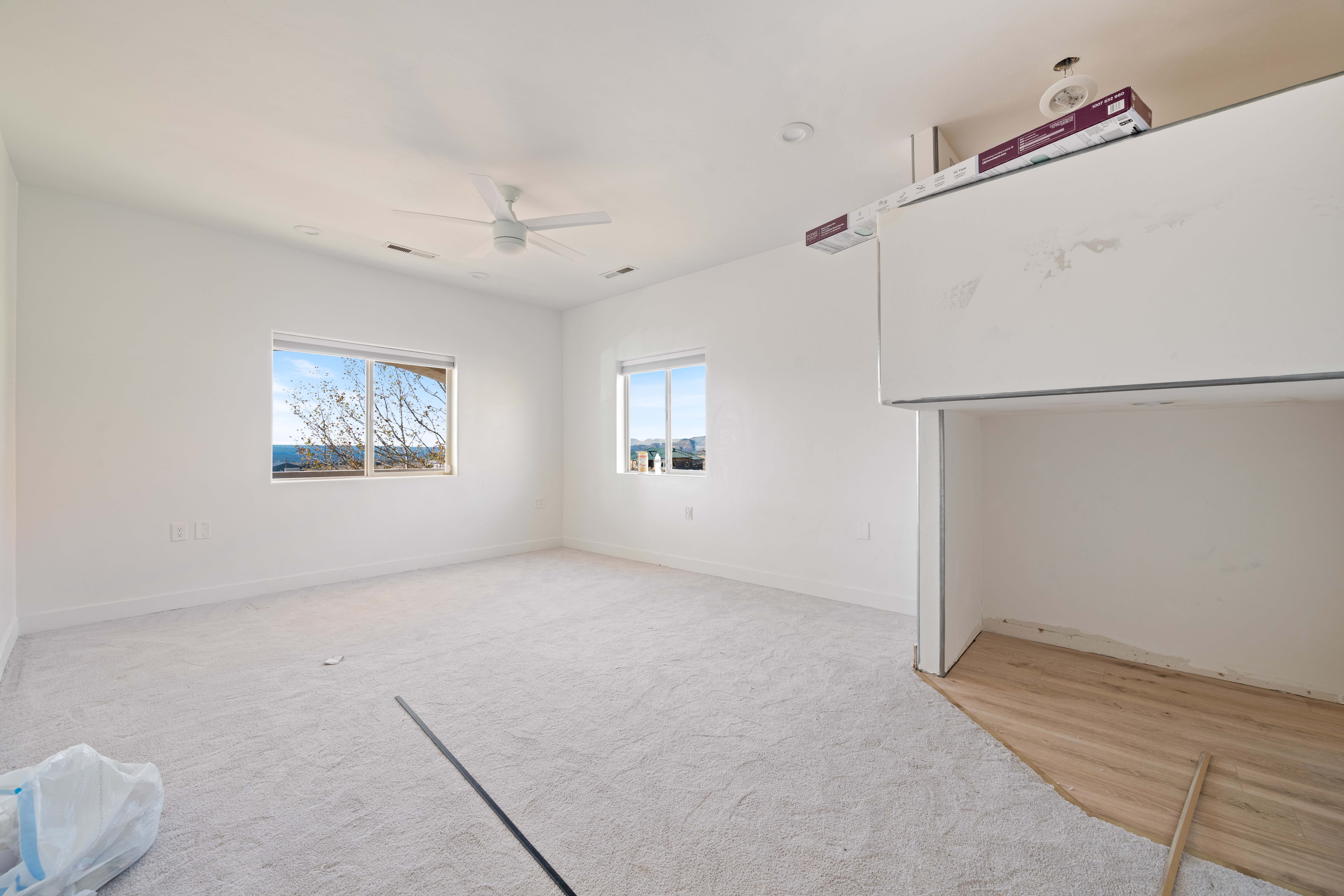 Empty room featuring ceiling fan and light carpet