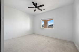 Empty room with light colored carpet and a ceiling fan