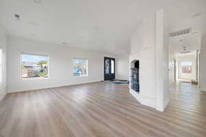 Unfurnished living room with light wood-style floors and healthy amount of natural light