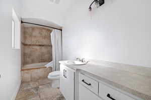 Full bathroom with tiled shower / bath combo and vanity