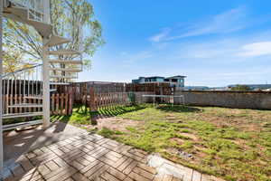 Deck with a patio, a fenced backyard, stairway, and a trampoline