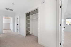 Unfurnished bedroom with light colored carpet and a closet