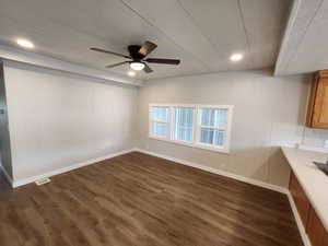 Unfurnished dining area with dark wood-style floors, a decorative wall, a ceiling fan, and recessed lighting