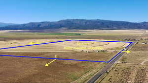 Overview of rural landscape with a mountain backdrop and property parcel outlined