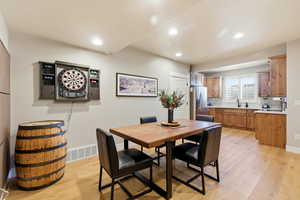 Dining room with light wood-style flooring and recessed lighting