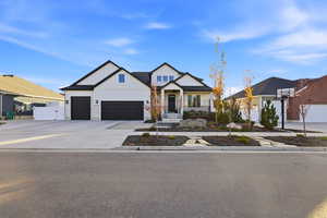 Modern farmhouse with board and batten siding, driveway, and an attached garage