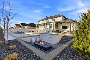 Rear view of property with a patio, an outdoor living space with a fire pit, a ceiling fan, stucco siding, and a fenced backyard