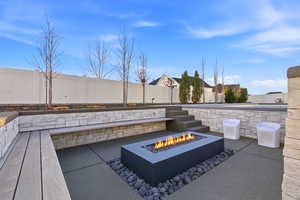 Fenced backyard featuring a fire pit and a patio area