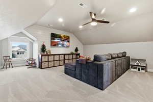Home theater featuring lofted ceiling, light colored carpet, and wood walls