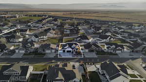 Aerial view of property and surrounding area with nearby suburban area and mountains