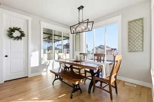 Dining area featuring light wood finished floors and a chandelier