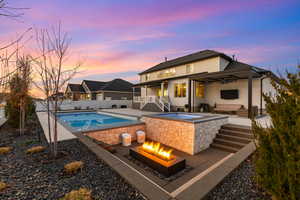Back of property featuring a patio, a ceiling fan, an outdoor living space with a fire pit, and stucco siding