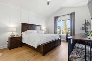 Bedroom featuring light wood-style floors, vaulted ceiling, and ceiling fan