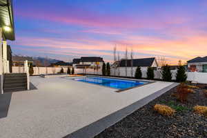 View of swimming pool featuring a patio, a fenced backyard, and a pool with connected hot tub