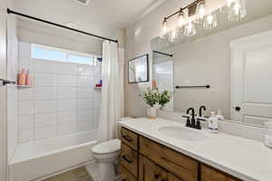 Bathroom with shower / bath combination with curtain and vanity