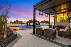 Fenced backyard with a patio area, an outdoor living space, a ceiling fan, a pool with connected hot tub, and area for grilling