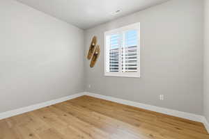 Unfurnished room with baseboards and wood-type flooring