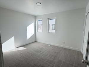 Empty room featuring baseboards and light colored carpet