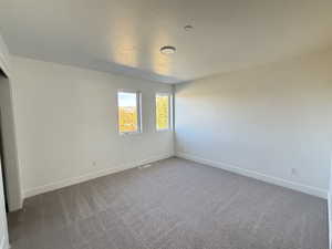 Unfurnished room with carpet flooring and baseboards