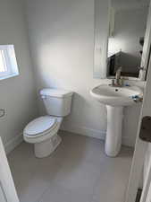 Half bath with baseboards and light tile patterned flooring