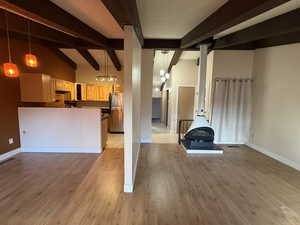 Unfurnished living room featuring a textured ceiling, light wood-style floors, and a wood stove