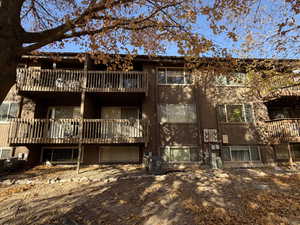 Rear view of house with a balcony and brick siding