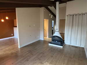 Spare room with high vaulted ceiling and wood finished floors