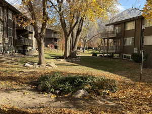 View of grassy yard with a balcony
