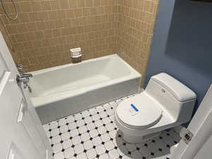 Bathroom with tile patterned floors and shower / bath combination