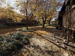 View of yard featuring a balcony and a wooden deck