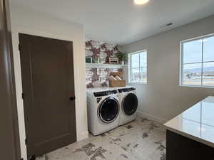 Laundry room featuring washing machine and dryer and baseboards