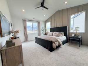 Bedroom featuring a decorative wall, a mountain view, lofted ceiling, a ceiling fan, and light colored carpet