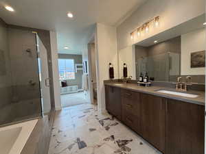 Full bath featuring a bath, double vanity, a shower stall, and recessed lighting