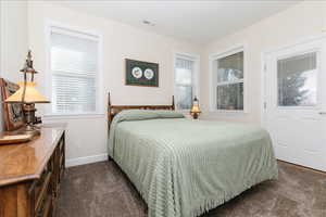 Bedroom with dark carpet and baseboards