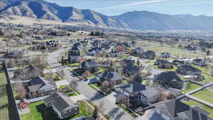 Aerial view of property and surrounding area with a mountainous background and nearby suburban area