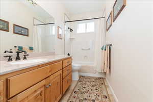 Bathroom with shower / tub combo with curtain, vanity, and light tile patterned floors