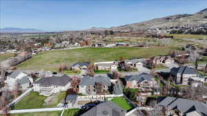 Aerial view of property and surrounding area with a mountainous background and nearby suburban area
