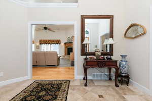 Corridor with crown molding and light tile patterned flooring