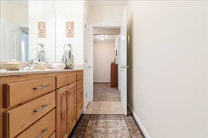 Bathroom with vanity and light colored carpet
