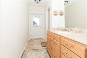Doorway to outside featuring a sink and baseboards