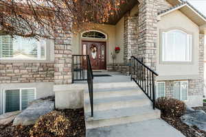 Entrance to property featuring stone siding and stucco siding