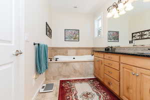 Bathroom featuring double vanity, a bath, and light tile patterned floors