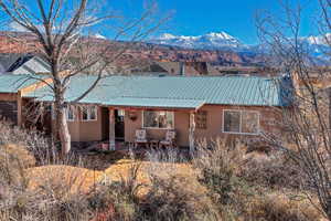 View of front facade featuring stucco siding, a metal roof, a patio, and a mountain view