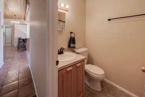 Bathroom with a chandelier, vanity, and light tile patterned flooring