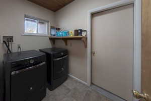 Washroom with washing machine and dryer and baseboards