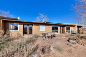 Back of house with french doors, a patio area, stucco siding, outdoor dining space, and a metal roof