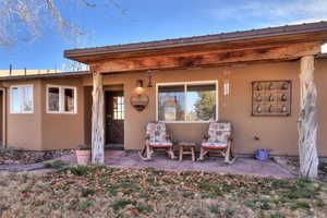 Doorway to property featuring stucco siding and a patio