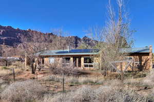 View of front of home featuring solar panels, a metal roof, and a mountain view