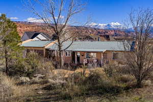 Back of house with a mountain view, stucco siding, and a metal roof